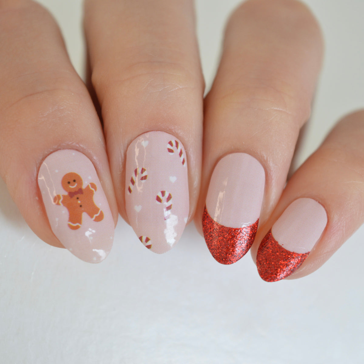 Personail Holly Christmas nail polish wraps on almond nails with gingerbread man, candy canes and red glitter French tips