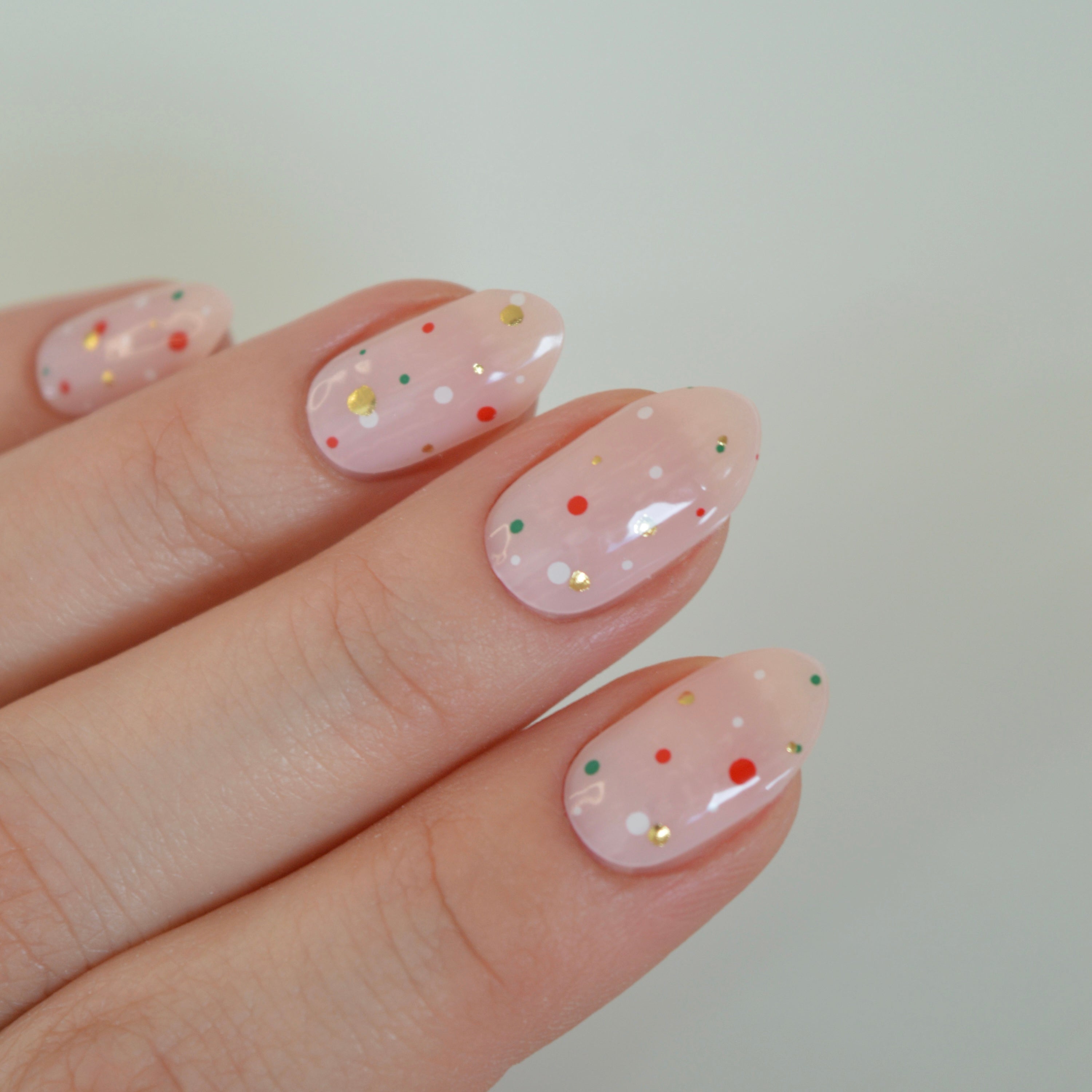 Freckles Super Jellies, sheer pink gel nails with red, green, white and gold dots
